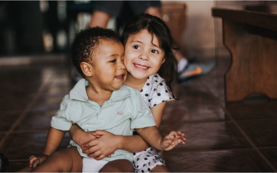 Two toddlers smiling